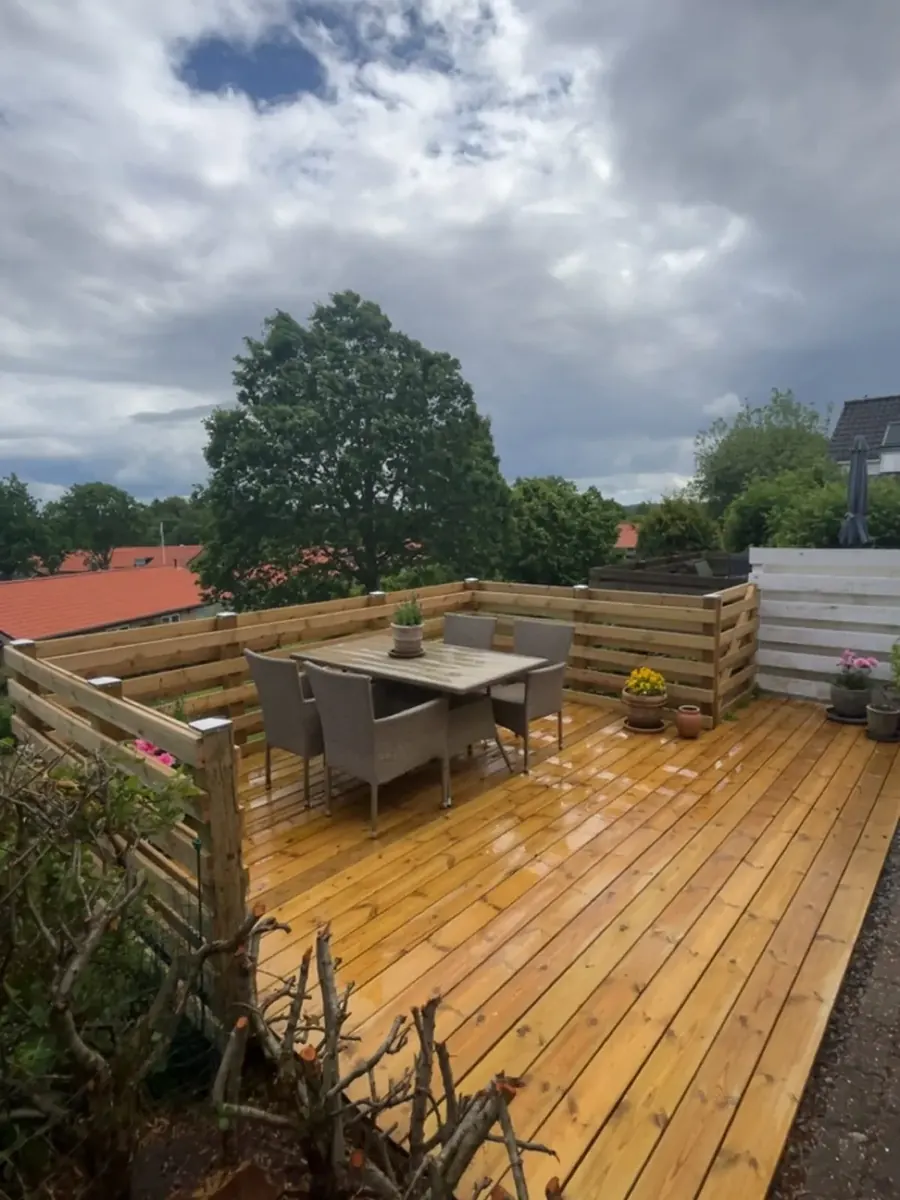 Terrasse med læhegn efter: nye brædder og nyt læhegn